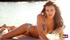 Gorgeous Russian model in bikini poses while having collared cheetah beside her.